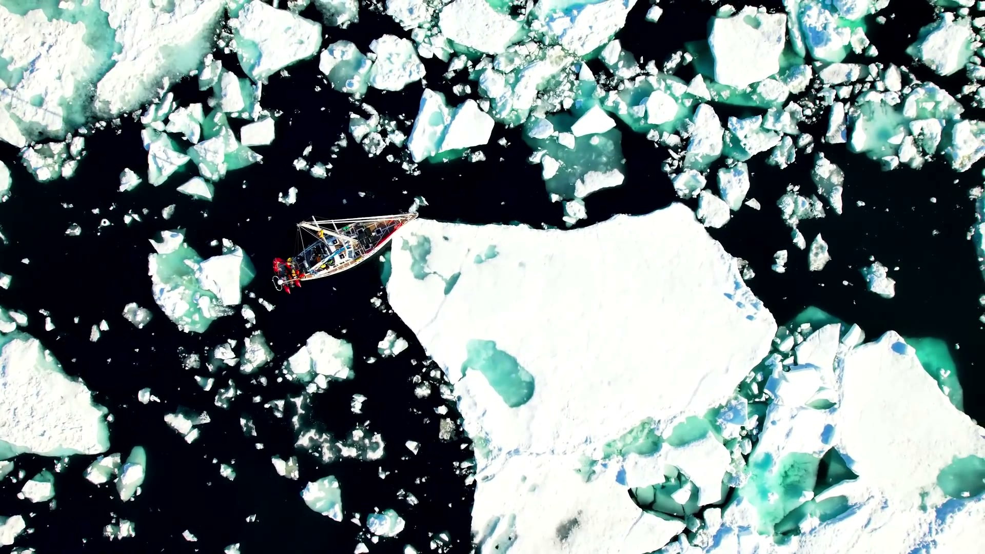 Segelyacht zwischen Eisschollen, senkrecht von oben